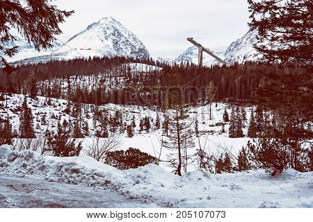 Solisko peak with springboard for ski jumping Strbske pleso Slovak republic. Retro photo filter. Winter mountains.