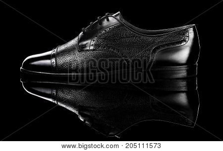 Black oxford polished shoes on black miror background.Shoes shine.