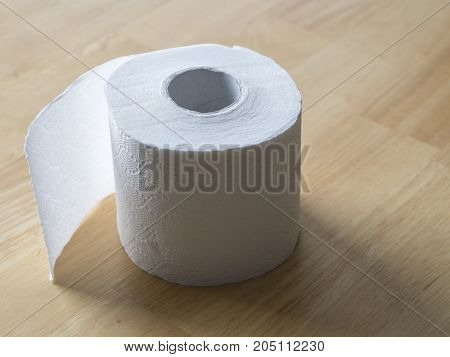 close up white roll of toilet paper on wooden background