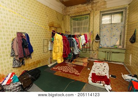 Refugees' clothes is dried on the rope in the temporary dirty old apartment and sleeping place on the floor for refugees