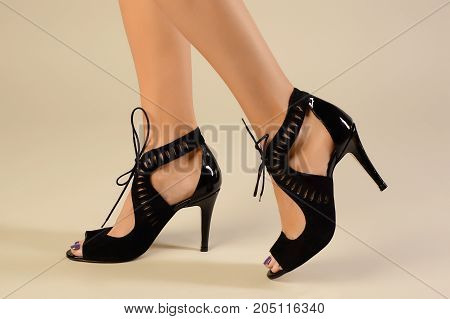 Tanned Female Legs In High Heels Isolated On Gray Background.