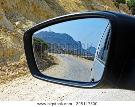 Landscape of the island of Kos (Greece) seen in the rear view mirror of a car