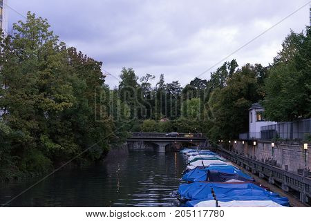 small boats in canal with tree and water reflection for fishing and sailing with raincovers at evening