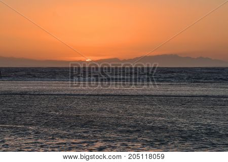 sunrise over the sea against the backdrop of the mountains