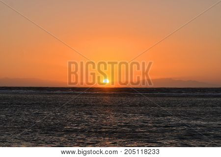 sunrise over the sea against the backdrop of the mountains