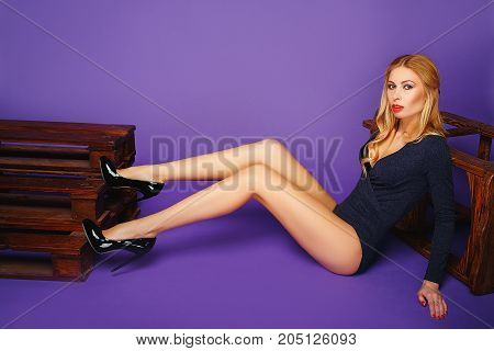 fashion interior photo of gorgeous young woman with blond hair in black lingerie posing at studio