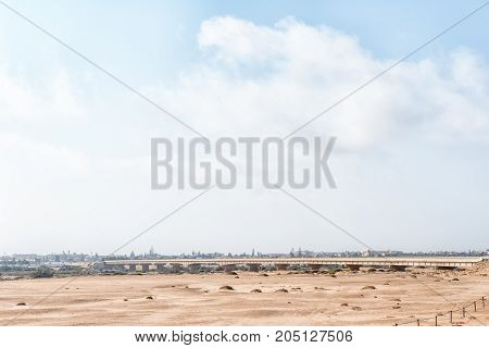 The road bridge over the Swakop River with a misty Swakopmund in the back