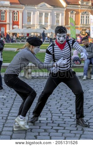 TIMISOARA ROMANIA - MARCH 31 2017: Pantomime couple with painted face present on the street inside the CheckART Carnival organized by the City Hall Timisoara. Union Square.