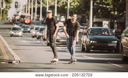 Two Skateboarders Riding Skateboard Slope On The City Streets