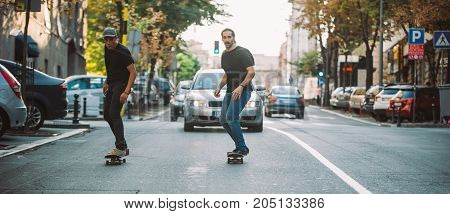 Two Skateboarders Riding Skateboard Slope On The City Streets