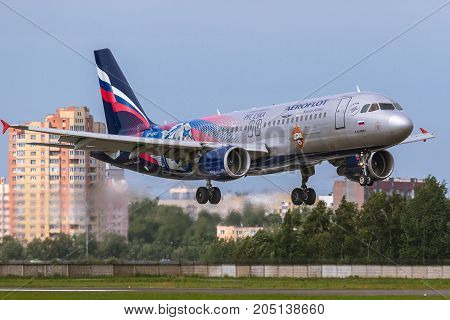 Pulkovo, Saint-Petersburg, Russia - August 10, 2017:   The airplane  Airbus A320 of Aeroflot  airlines is landing on the runway against the background of the city skyline. Has a special livery - PFC CSKA