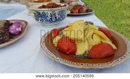 Traditional Romanian cheese and tomato dish on a outdoor buffet