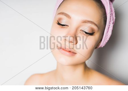 Girl with beautiful clean skin and a towel on her head close-up