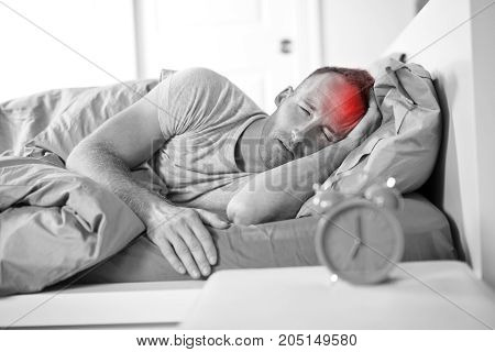 A Portrait of Young Caucasian man in bed with headache