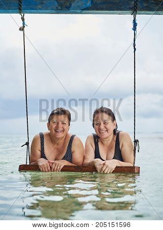Two happy smling old woman on sea water. Mature womans on vacation