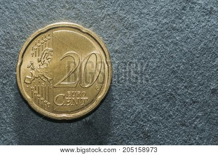 A 20 cent euro coin on a grey background