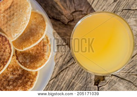 Breakfast with pancakes and orange juice on a wooden table