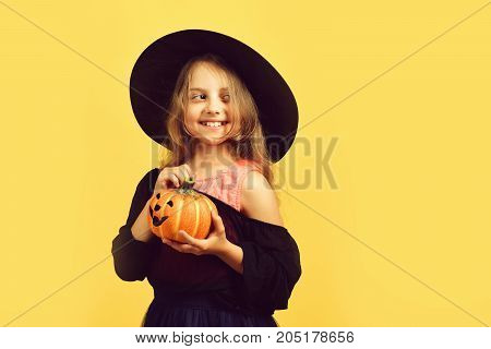 Halloween And Autumn Holiday Concept. Girl With Carved Orange Pumpkin