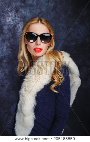 Stylish blonde in arctic fox and sun glasses.