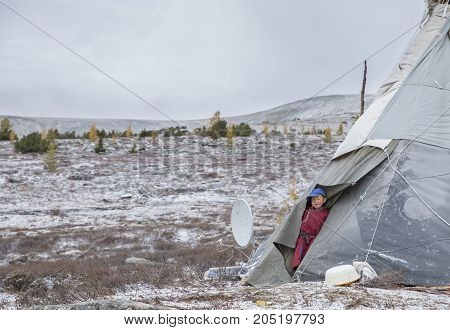 Tsaatan Boy Looing Out Of The Family Yurt In A Cold Autumn Morning