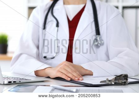 Close up of a unknown female doctor's hands. Physician is ready to consult and halp patients. Medicine and health care concept