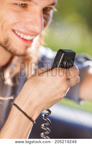 Comunication talking while drive auto walkie talkie concept. Young man driving car using cb radio having fun