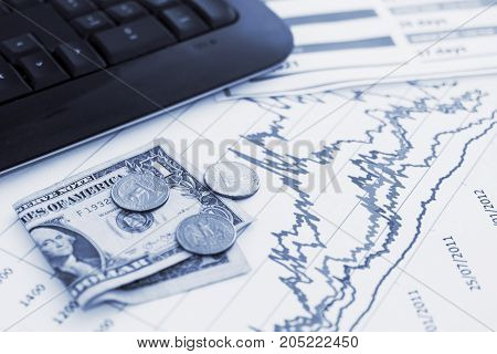 Financial charts with some money and a computer keyboard