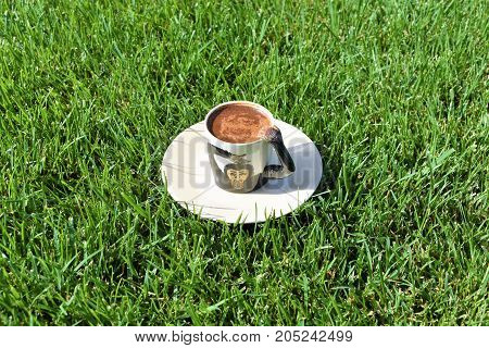 Turkish coffee background. coffee grounds on the bottom of the mug. a cup on the grass. green meadow and white tableware. fortune telling, monkey cup, monkey background, funny and cute cup, green background