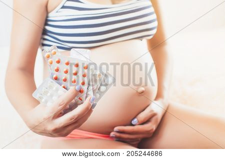 Pregnant Girl In The Hands Holding A Lot Of Pills