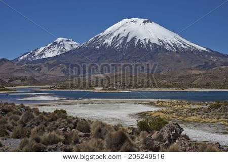 Volcanoes Parinacota and Pomerape in Lauca National Park high on the Altiplano of northern Chile. In the foreground lakes known as Lagunas de Cotacani