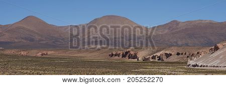 Eroded cliffs along the wide valley of a tributary of the River Lauca high on the Altiplano of northern Chile in Lauca National Park.