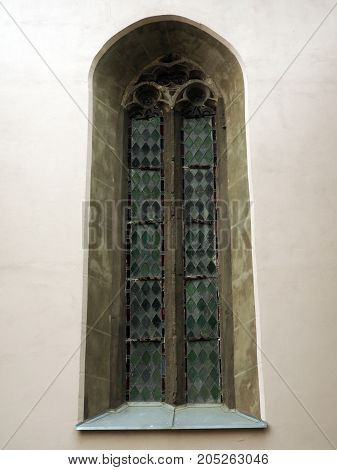 old beautiful window in the wall with stained glass