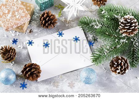 christmas greeting card with christmas decorated with cones green branches fir trees on gray concrete background copy space.new year