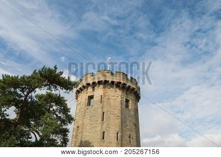 Warwick, United Kingdom - September 19, 2016: View of the Medieval castle tower and gatehouse from within the castle gardens and people enjoying the setting, Warwick, Warwickshire