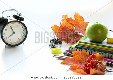 Colorful school supplies book and alarm clock on white background. Top view flat lay. Top view copy space. Back to school.