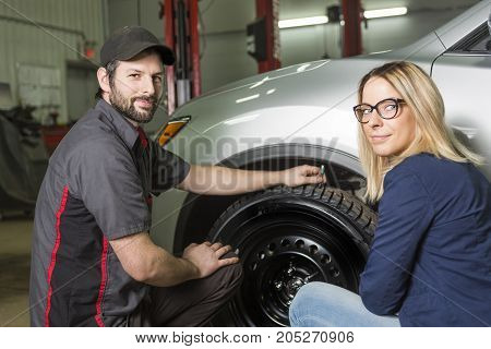 An auto mechanic and female customer in garage