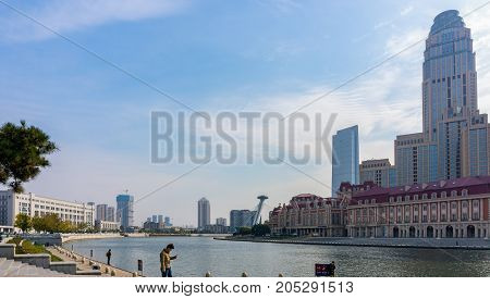 Tianjin, China - Nov 1, 2016: Commercial skyline across the Haihe River. Buildings in contrasting modern and old architectural style.