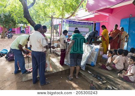 PONDICHERY PUDUCHERY INDIA - SEPTEMBER 04 2017. Outdoor meeting of the children of the school with uniforms sitting on the floor waiting for sport equipments as a gift from an association.