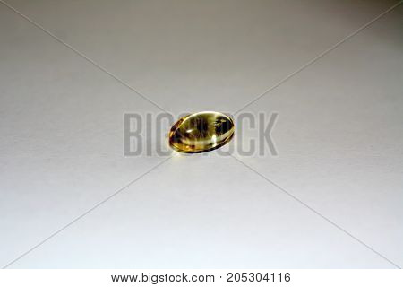 Transparent yellow capsule of fat-soluble vitamins. Vitamin A, E.