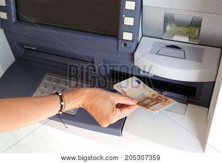 Hand Of Young Woman While Withdrawing Banknotes From An Atm In E