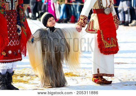 Razlog, Bulgaria - January 14, 2017: Child in traditional carnival kuker costume clothing at Kukeri festival Starchevata