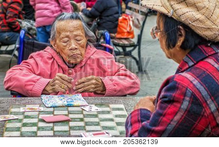Women Play Cards In New York City Chinatown Park
