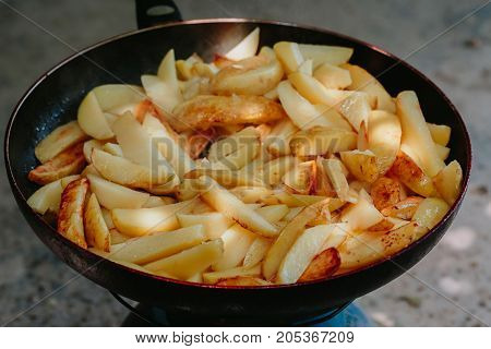 Fried potatoes in a frying pan Outdoors