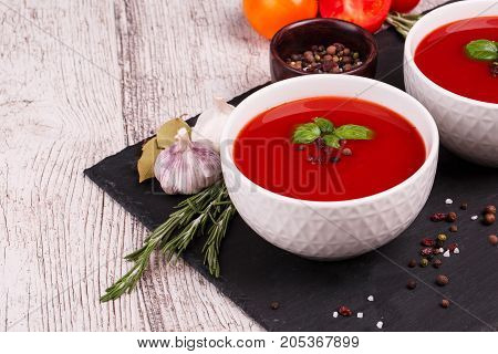 Soup in a bowl with dill, sour cream and black bread on wooden background. National dish of Ukrainian cuisine.