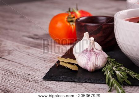 Soup in a bowl with dill, sour cream and black bread on wooden background. National dish of Ukrainian cuisine.