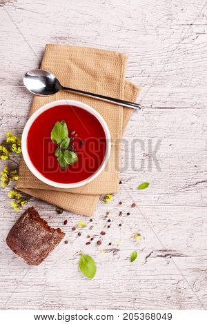 Soup in a bowl with dill, sour cream and black bread on wooden background. National dish of Ukrainian cuisine.