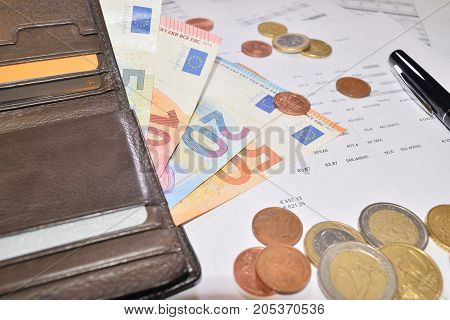 leather wallet with various euro banknotes and coins
