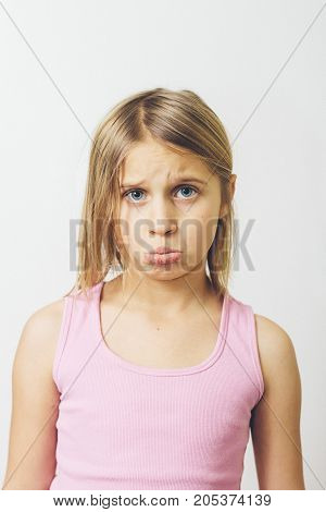 a little girl pouting in front of camera.
