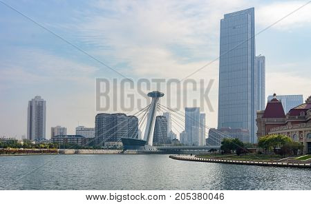 Tianjin, China - Nov 1, 2016: Chingfen Bridge spans across the Haihe River. Backgropund buildings in contrasting modern and old architectural style. Viewed from Tianjin Railway Station.