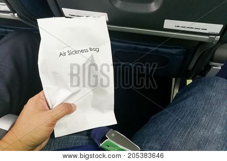 Airsick Nauseous Person Holding The Air Sickness Vomit Bag